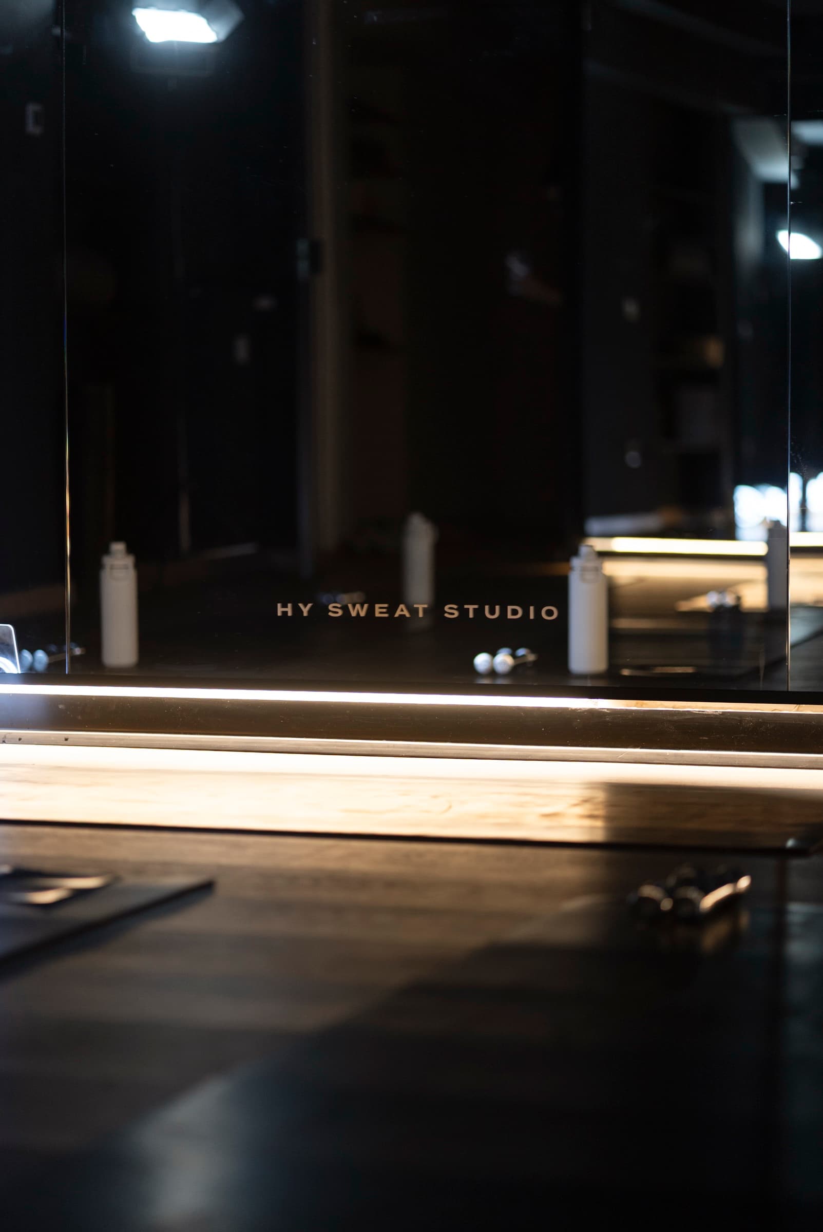 Mirrored reception wall with HY Sweat Studio lettering